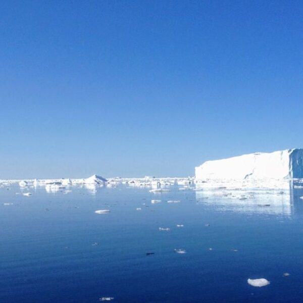 Una imagen aérea de la Antártida, mostrando vastos campos de hielo y una misteriosa anomalía atmosférica que se asemeja a un vórtice.