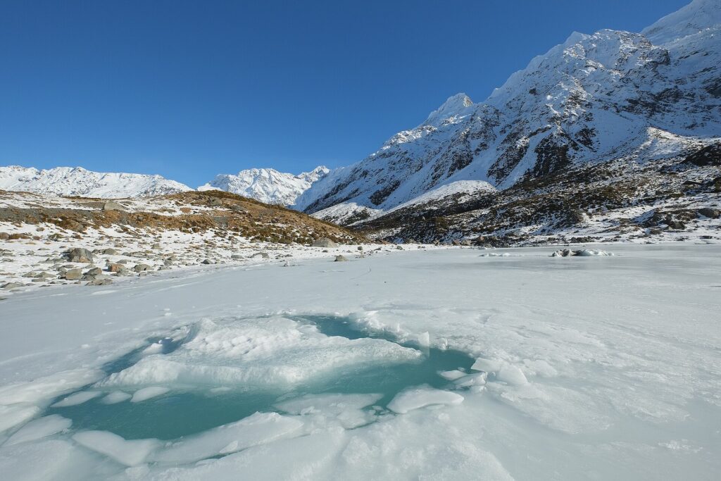 Superficie helada de un lago con grietas largas que se cruzan bajo luz invernal