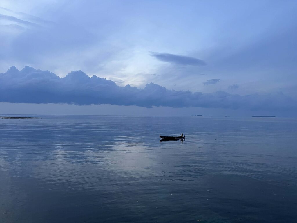 Mar en calma al amanecer con una capa fina de niebla pegada a la superficie del agua