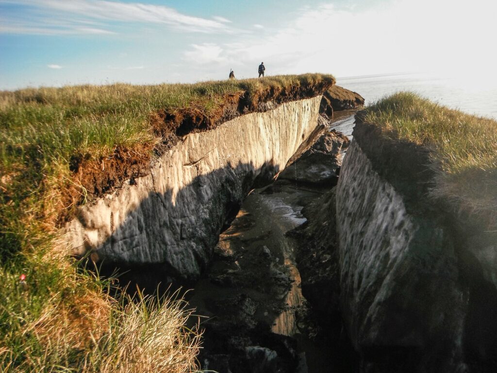 Talud de permafrost expuesto junto a la costa con capas de hielo y sedimento visibles