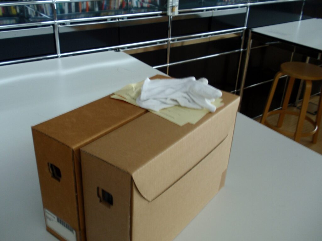 Cajas de archivo apiladas en estanter&iacute;as met&aacute;licas de un dep&oacute;sito documental