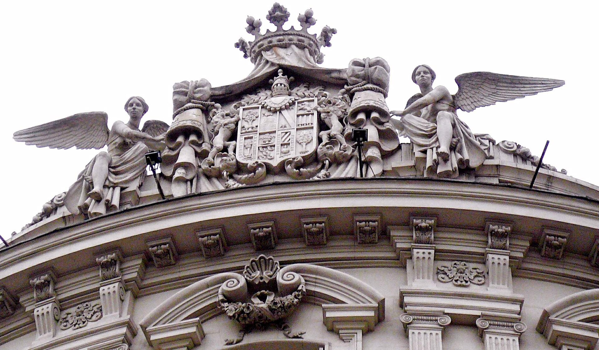 Fachada de piedra clara de un palacio decimonónico con balaustrada y ventanas altas en la ciudad