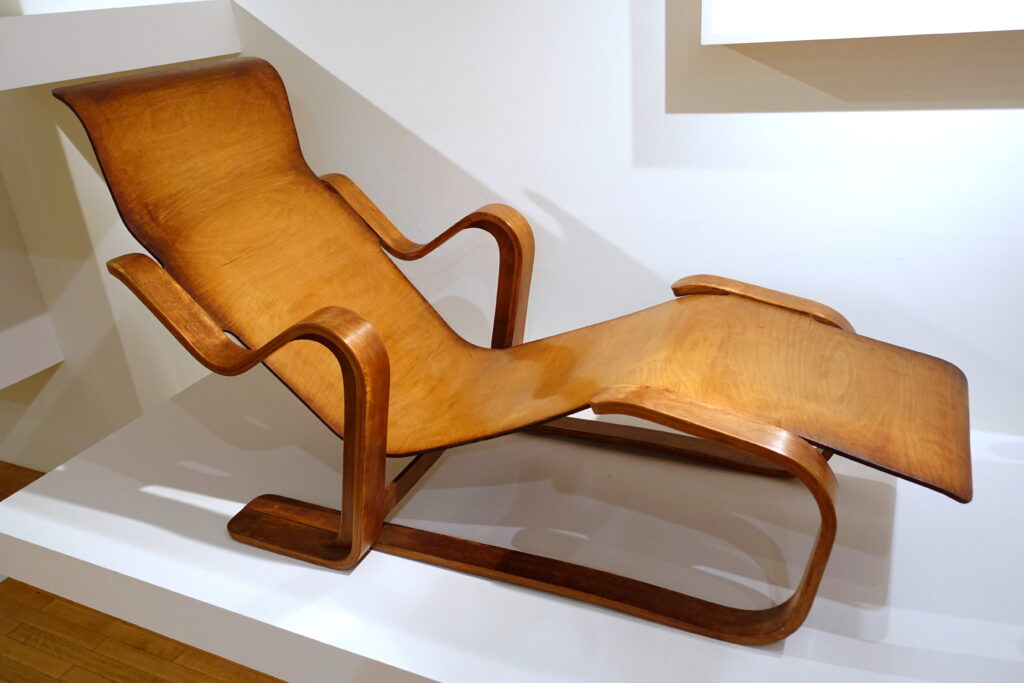 Sill&oacute;n reclinable con unos auriculares apoyados sobre el respaldo en una sala peque&ntilde;a y vac&iacute;a